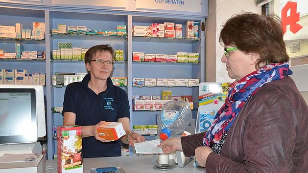 Apothekerin Olga Merdian spricht russisch und hat Hasan stets seine Medikamente gegen Diabetes ausgeh&auml;ndigt. Uschi Schmidt (rechts) l&ouml;st ein Rezept ein und m&ouml;chte die Arznei nach Kasachstan schicken. Inzwischen wurden Spendendosen (vorne links) aufgestellt.  Foto: Bernhard Panzer