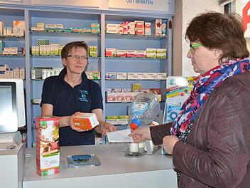 Apothekerin Olga Merdian spricht russisch und hat Hasan stets seine Medikamente gegen Diabetes ausgehändigt. Uschi Schmidt (rechts) löst ein Rezept ein und möchte die Arznei nach Kasachstan schicken. Inzwischen wurden Spendendosen (vorne links) aufgestellt.  Foto: Bernhard Panzer