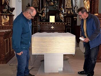 Kirchenpfleger Adam Schmitt (rechts) zeigt seinem Mithelfer Bernhard Kurz aus Zeegendorf das Reliquiengrab im Altar. Dort werden am Sonntag Reliquien der Hl. Märtyrer Amantia und Candidus vom Erzbischof feierlich bestattet werden. Fotos: Andrea Spörlein
