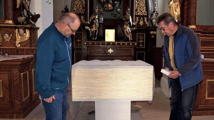 Kirchenpfleger Adam Schmitt (rechts) zeigt seinem Mithelfer Bernhard Kurz aus Zeegendorf das Reliquiengrab im Altar. Dort werden am Sonntag Reliquien der Hl. Märtyrer Amantia und Candidus vom Erzbischof feierlich bestattet werden. Fotos: Andrea Spörlein