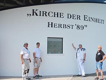 Ralf Luther, Vorsitzender des Vereins Autobahnkirche A 71 e.V. hier mit Stefan Neuhöfer (rechts)  freut sich über die gelungene Gestaltung zum nun sichtbaren Namen der kleinen Kirche an der A 71. Mit auf dem Bild (links) Geselle Ludwig Saum und Auszubildender Niklas Lurz. Foto: Hanns Friedrich