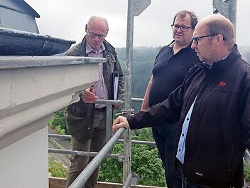 In luftiger Höhe begutachten (von links) die Architekten Peter Kropf und Sandro Selig sowie Kirchenpfleger Bernd Peter die Schäden an der Außenfassade der Wilhelmsthaler Kirche.