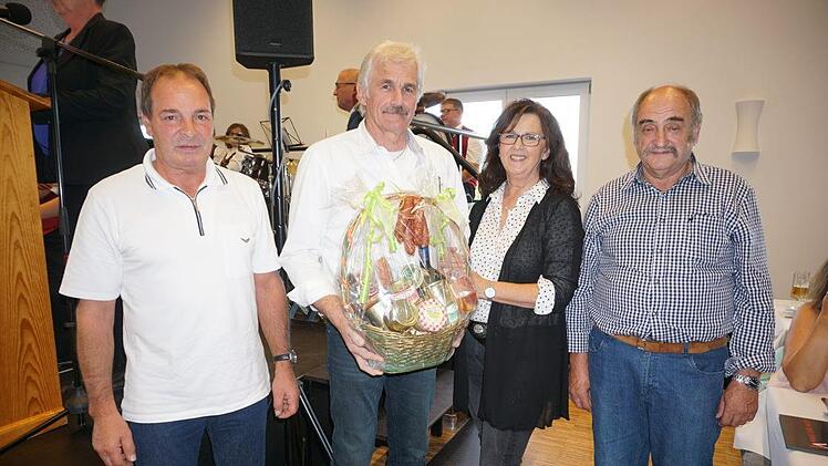 Günther Schmitt (Zweiter von links) hatte die Bauleitung inne. Ihm und  seiner Frau Berta wurde stellvertretend für die vielen Helfer von der  Dorfgemeinschaft gedankt. Den Präsentkorb übergaben Frank Hartmann und  Ewald Wehner. Foto: Marion Eckert