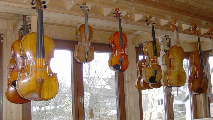 An Kliers Fenster hängen verschiedenste Geigen.
