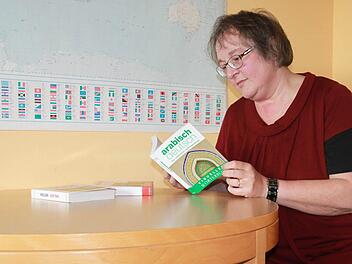 Um sich mit den Flüchtlingen verständigen zu können, nutzt Beate Ehl oft Wörterbücher mit Bildern. Manchmal deutet sie auf Bilder oder Gegenstände, damit die Flüchtlinge sie verstehen.  Foto: Lisa Kieslinger