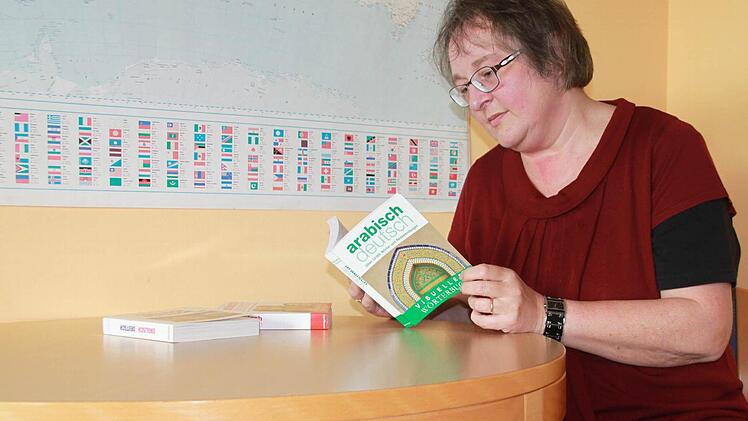 Um sich mit den Flüchtlingen verständigen zu können, nutzt Beate Ehl oft Wörterbücher mit Bildern. Manchmal deutet sie auf Bilder oder Gegenstände, damit die Flüchtlinge sie verstehen.  Foto: Lisa Kieslinger