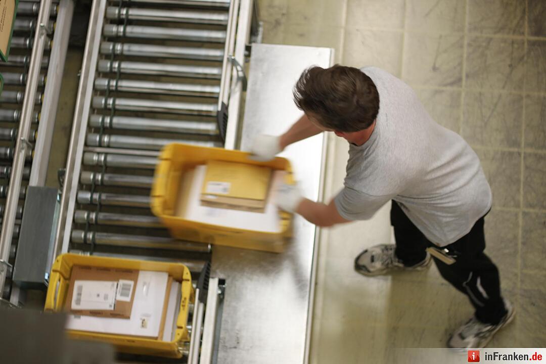Im "Bahnhof" werden die schweren Großbriefkisten weiterverarbeitet. Ein Job, der in die Oberarme geht.