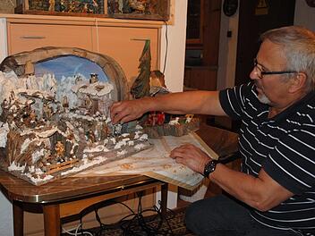 Klaus Kneuer bringt die Figuren auf einer seiner 30 Krippen in die richtige Position. Diese Darstellung hat sogar einen Wasserlauf.Christoph Wiedemann