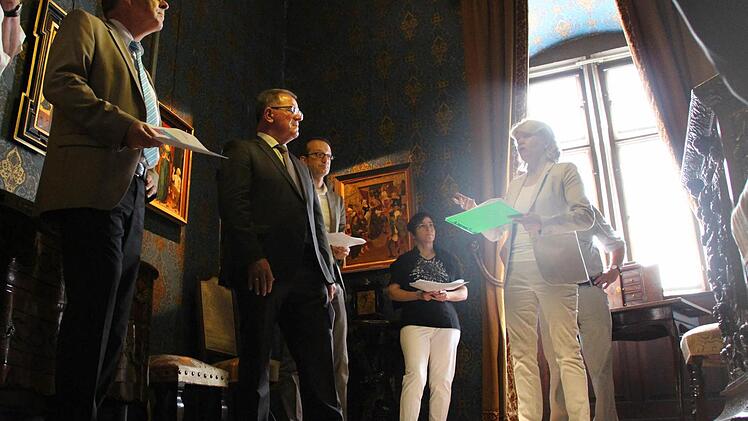 Museumsleiterin Annette Späth (rechts) stellt Bezirkstagspräsident Erwin Dotzel (2 v. l.) vor, wie das Schloss Aschach umgestaltet werden soll. Foto: Benedikt Borst