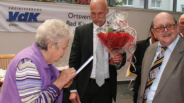 Bevor OB Kay Blankenburg die Blumen überreichen kann, muss Anni Konrad erst den Text der Urkunde genau studieren. Rechts der wiedergewählte Vorsitzende Roland Fenn.