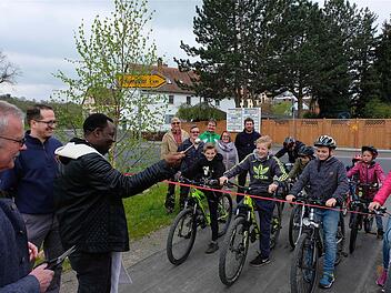Die Radler warten auf das Startsignal, nachdem Pfarrer Dr. Blaise Okpanachi den Segen für den neuen Geh- und Radweg erteilte.  Foto: Gerd Schaar