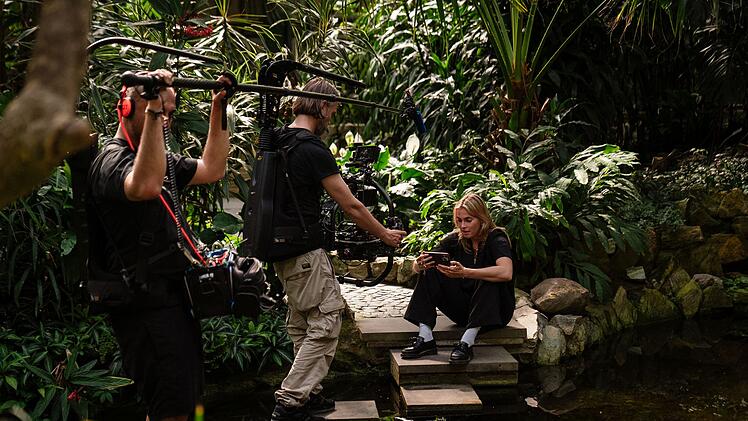 Filmaufnahmen mit Stürmerin Laura Freigang: Sie sitzt zwischen Palmen in einem botanischen Garten. Wann wird ihr die Öffentlichkeit zu viel?