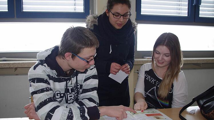 Nadja Jonak und Jonas Hümmer (von links, sitzend) geben Merve Bozat (stehend) einen Einblick in den Französisch-Unterricht in der Einführungsklasse.  Foto: Heike Schülein