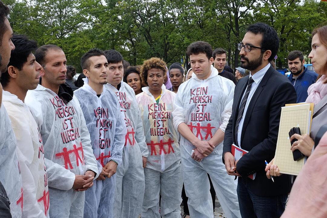 Flüchtlinge sprechen mit Bamf-Sprecher Ata. Foto: Nikolas Pelke