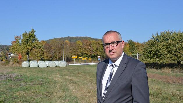 Am Aschacher Kreisel (Marktgemeinde Bad Bocklet) will die Handelskette Rewe einen Verbrauchermarkt ansiedeln. B&uuml;rgermeister Andreas Sandwall steht auf dem betreffenden Grundst&uuml;ck, im Hintergrund ist der Verkehrskreisel zu sehen.  Foto: Isolde Krapf