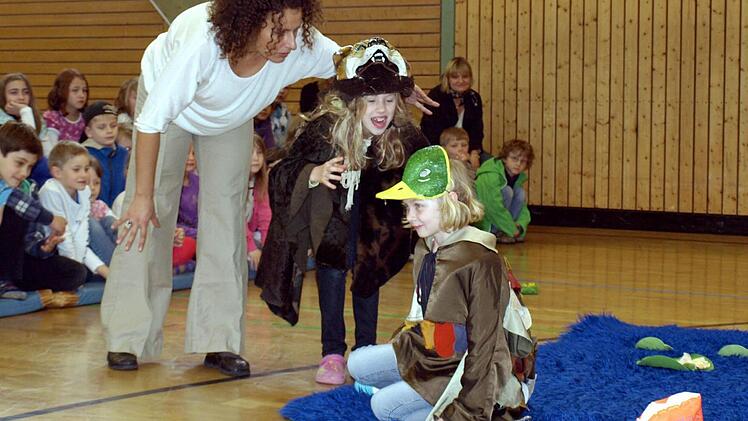 Der böse Wolf (Sophia Lorenz) erschreckt das kleine Entchen (Emma Müller), das so schön im Teich geplanscht hat. Links Julia Ikodinovic.
