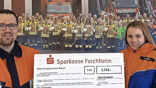 Kommandant Sebastian Müller und Jugendsprecherin Luisa Prell halten den symbolischen Spendenscheck hoch.