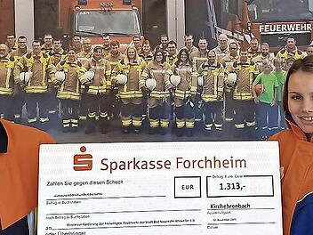 Kommandant Sebastian Müller und Jugendsprecherin Luisa Prell halten den symbolischen Spendenscheck hoch.