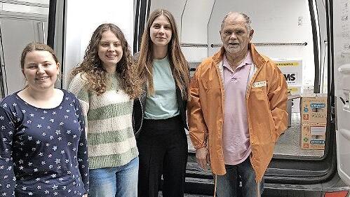 Die Sch&uuml;lerinnen (von links) Laura Wasser, Mona Metz und Lara Heuring sowie Herr Memmel von der Tafel mit dem gepackten Kleintransporter.