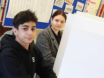 Salam Mushtaha und Melissa Steinert fühlen schon mal vor, wie es sein wird, wenn sie in zwei Wochen hinter dem Sichtschutz versteckt ihr Kreuzchen machen werden. Sie und ihre Klassenkameraden nehmen die Landtagswahl zum Anlass zu üben, wie man eigentlich wählt. Fotos: Carmen Schmitt