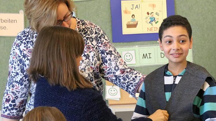 Badr stellt Friedrich von Luxburg dar. Hier probiert er eine Weste an, die die Museumspädagogin Katja Kraus mitgebracht hat. Die Klassenlehrerin Beatrice Rose-Ebel hilft bei der Anprobe. Foto: Kathrin Kupka-Hahn