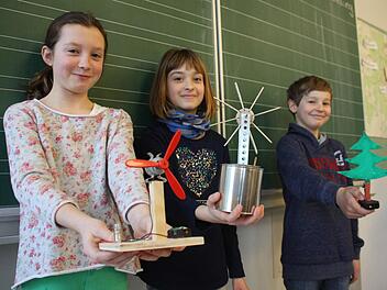 Marisa (von links), Nelly und Moritz zeigen ihre Werke: ein Ventilator, eine Eislöffelturbine und ein LED-Weihnachtsbaum.  Fotos: Robert Huger
