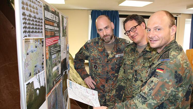 Truppenübungsplatzkommandant Carsten Kobiger (von links) geht mit seinem Stellvertreter Jörg Göbel und dem Schießsicherheitsfeldwebel Andreas Pütz die Wanderrouten für den Wandertag am 9. August durch: Erstmals seit den 1970er Jahren ist das Militärgelände öffentlich zugänglich. Foto: Ralf Ruppert