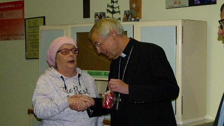 Im Namen aller Besucher der Wärmestube überreichte Petra eine Kerze und hatte wertvolle Tipps für den joggenden Erzbischof parat. Foto: Marion Krüger-Hundrup