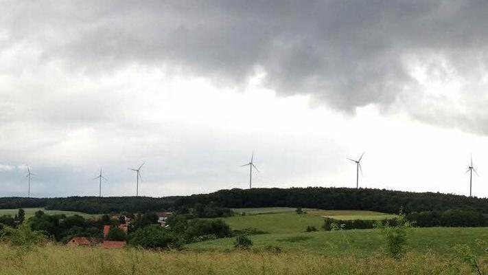Die Fotomontage zeigt, wie der geplante Bürgerwindpark im Sailershäuser Wald mit zehn Windrädern aussehen könnte. Fotografiert wurde vom Ortsausgang von Kleinmünster in Richtung Kleinsteinach. Foto: GUT