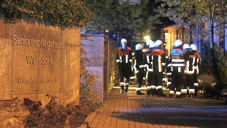 Feuerwehrleute haben - auch nachdem der Brand gelöscht ist - ein wachsames Auge auf das Seniorenheim. Fotos: news5/Herse
