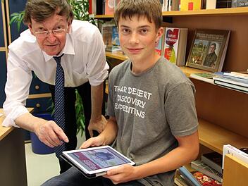 So einfach lesen sich E-Books auf dem Tablet: Bibliotheksleiter Dieter Sternecker und Praktikant Michael Hahn probieren die neue Technik aus. Foto: Sebastian Vogt