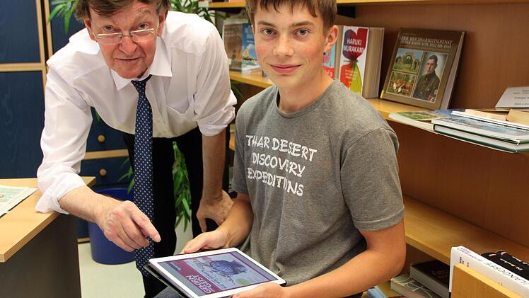 So einfach lesen sich E-Books auf dem Tablet: Bibliotheksleiter Dieter Sternecker und Praktikant Michael Hahn probieren die neue Technik aus. Foto: Sebastian Vogt