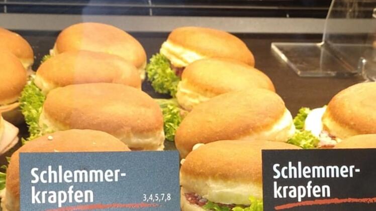 Schlemmekrapfen mit Salat und Aufschnitt in einer Theke. Ungewöhnliche Kombination sorgt für Aufmerksamkeit in einer Bäckerei.