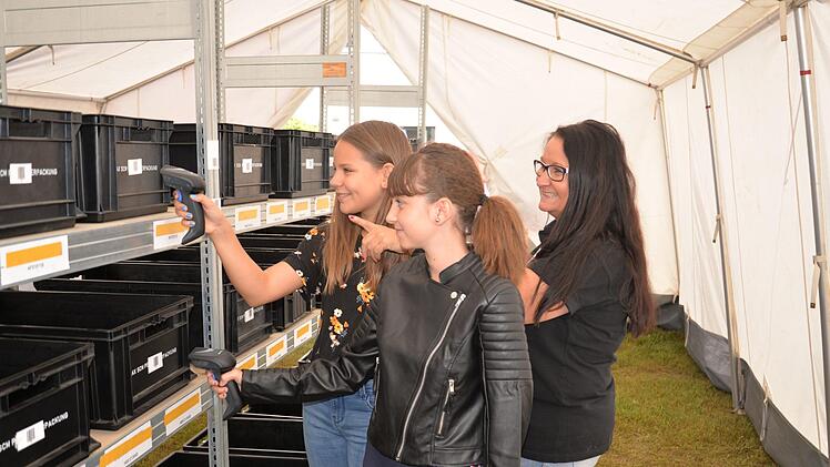 Sophia (Vordergrund) und Hannah stellen Pakete mithilfe eines Scanners für die Firma Hegele zusammen. Foto: Franka Struve