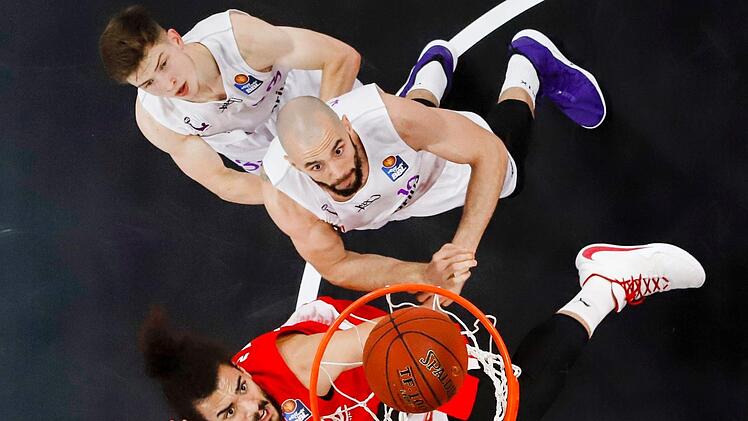 Brose-Center Assem Marei (zehn Punkte/acht Rebounds) hat sich gegen Dennis Kramer (rechts) durchgesetzt und legt den Ball in den Korb; hinten der Göttinger Aufbauspieler Bennet Hundt. Foto: Daniel Löb
