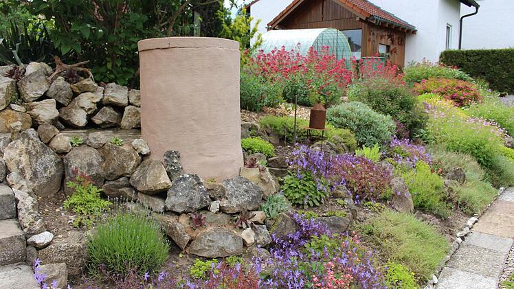 Der Staudengarten an der Hanglage hinterm Haus mit der Zisterne aus Schachtringen. Foto: Evi Seeger