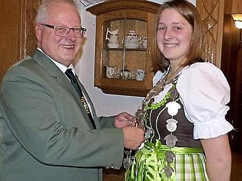 Schützenkommissar Stefan Sigmund (links) schmückt die Jungschützenkaiserin Johanna Wunner mit der Königskette. Fotos: Klaus-Peter Wulf