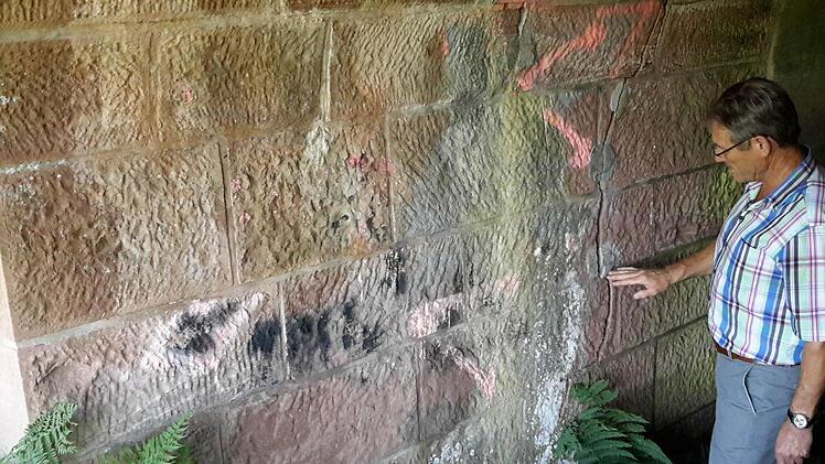 Bürgermeister Wilhelm Friedrich erklärt die sogenannten Bewegungsmarken in den Durchgängen. Mit ihnen wurde kontrolliert, ob das Bauwerk stabil ist oder sich im Laufe der Zeit verformt. Foto: Rolf Pralle