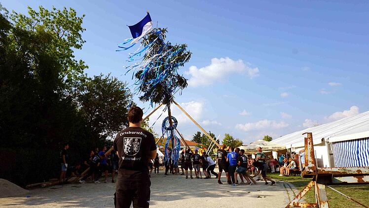 Mit viel Hau-Ruck stellten die Ortsburschen den Baum auf. Musikalisch unterstützt wurden sie vom Posaunenchor.