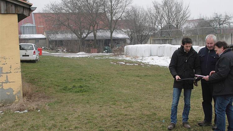 Zwischen dem vorhandenen Stall (links) und mit dem vorgeschriebenen Abstand zum Nachbargrundstück soll die 80 Quadratmeter große überdachte Auslauffläche entstehen, erklären Joachim und Eduard Mack Landwirtschaftsdirektor Wolfram Rapps. Foto: G. Bauer