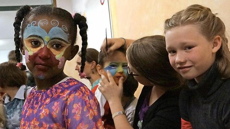 Kinder lassen sich schminken.
