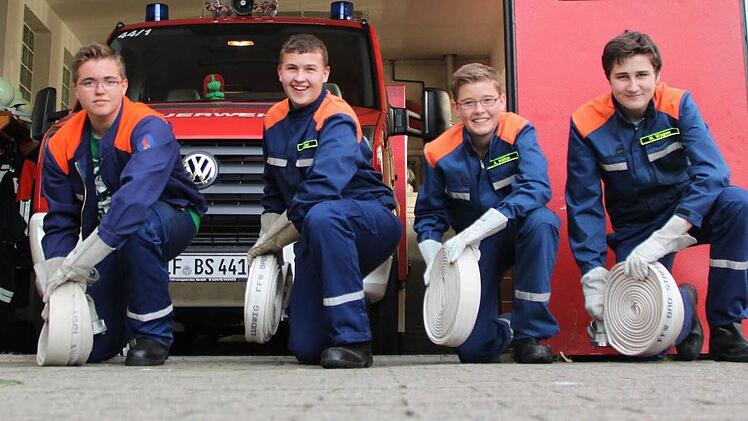 Marco Hälter, Lukas Zapf, Alexander Hälter und Mario Wagner (von links) beim zielgenauen Ausrollen der Feuerwehrschläuche