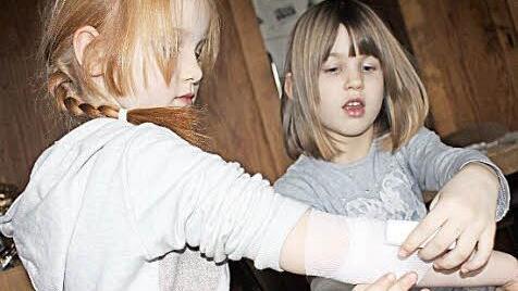Sina (rechts) verbindet Lina den Arm. Natürlich nur zur Übung.