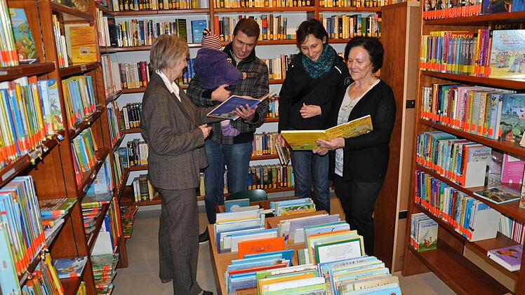 Die beiden Büchereileiterinnen Olga Back (links) und Gertrud Erhard (rechts) mit Büchereibesuchern beim Tag der offenen Tür. Foto: Daniel Wiener
