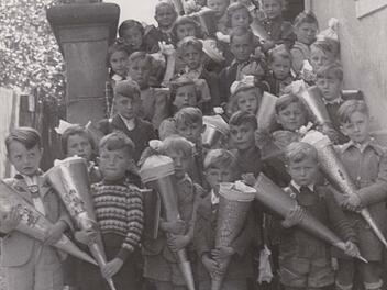Die Steinwiesener Kinder mit ihrer Lehrerin "Fr&auml;ulein" Grahl bei der Einschulung Mitte des vorigen Jahrhunderts. Im selben Schulgeb&auml;ude wohnten und unterrichteten damals auch Ordensfrauen der "Armen Schulschwestern von Unserer Lieben Frau" aus M&uuml;nchen. Das ehemalige Schulhaus ist heute Rathaus der Marktgemeinde Steinwiesen.  Foto: Schularchiv Steinwiesen