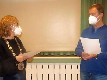 Bürgermeisterin Anja Gebhardt vereidigt den neuen Feldgeschworenen Helmut Pieger mit Maske und Corona-Abstand.