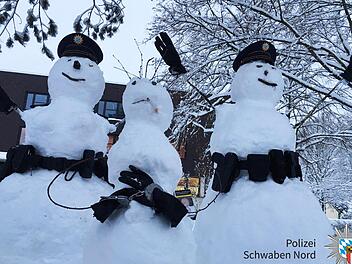Drei Schneem&auml;nner wurden von Polizisten des Polizeipr&auml;sidiums Schwaben Nord in ihrer Freizeit mit Gegenst&auml;nden best&uuml;ckt, um eine Verhaftungsszene darzustellen. Foto: Polizei Schwaben Nord/dpa