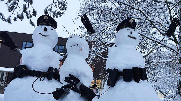 Drei Schneem&auml;nner wurden von Polizisten des Polizeipr&auml;sidiums Schwaben Nord in ihrer Freizeit mit Gegenst&auml;nden best&uuml;ckt, um eine Verhaftungsszene darzustellen. Foto: Polizei Schwaben Nord/dpa