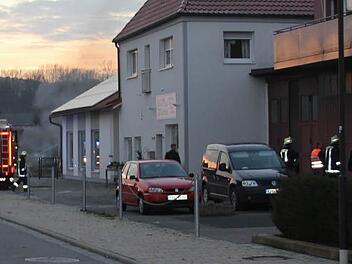 Aus der Lagerhalle am westlichen Ortseingang von Ebern (rechts im Bild) quoll der Rauch. Eine Palette und Kartons hatten Feuer gefangen (und werden im Hintergrund abgelöscht).  Foto: Ralf Kestel