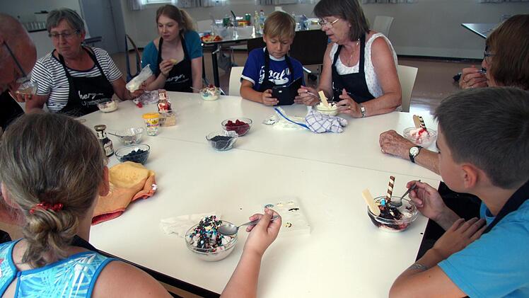 Die Kinder, ihre Großeltern und Betreuerin Simone Voit genießen gemeinsam die selbst gemachten Eissorten.